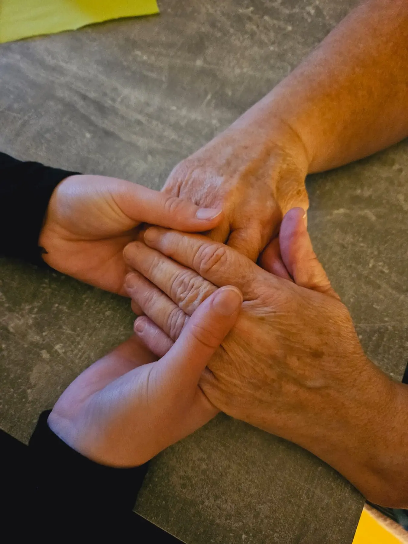 Pflegeteam Sonnenschein, Krankenschwester hält die Hände einer alten Frau