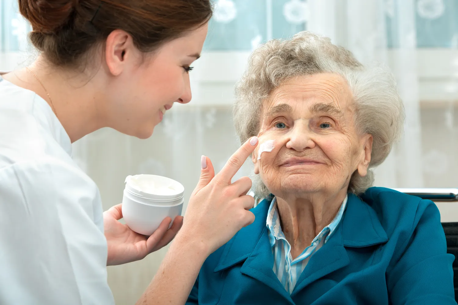 Ältere Frau wird von einer Krankenschwester zu Hause betreut